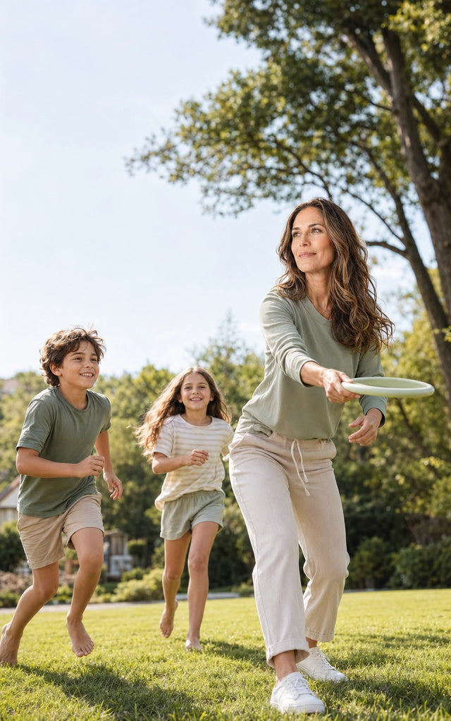 Energetic woman playing frisbee outdoors with her two children